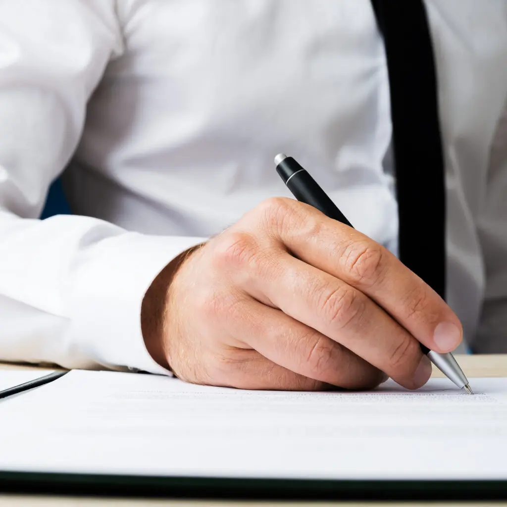 Man writing with a pen in a shirt